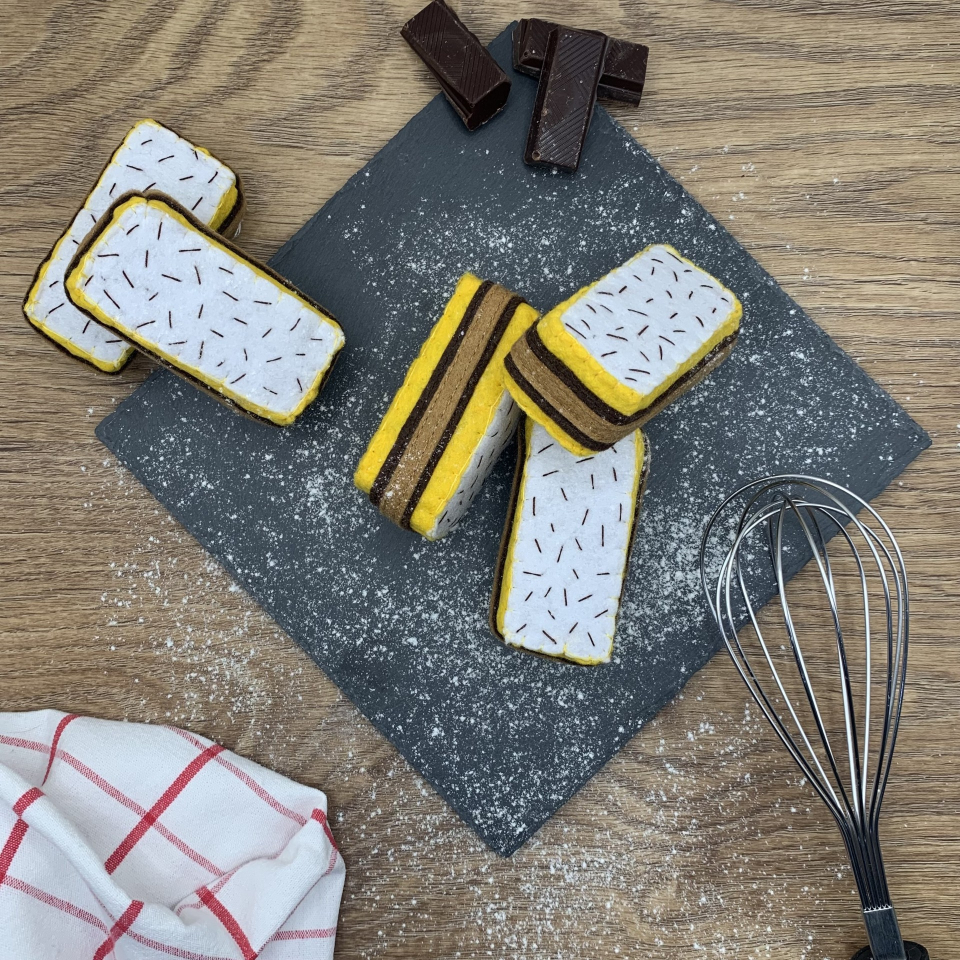 Part de gâteau napolitain en feutrine, dînette artisanale, douce et colorée pour enfants.